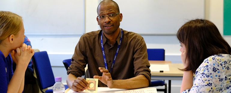 Man and two women sharing teaching ideas